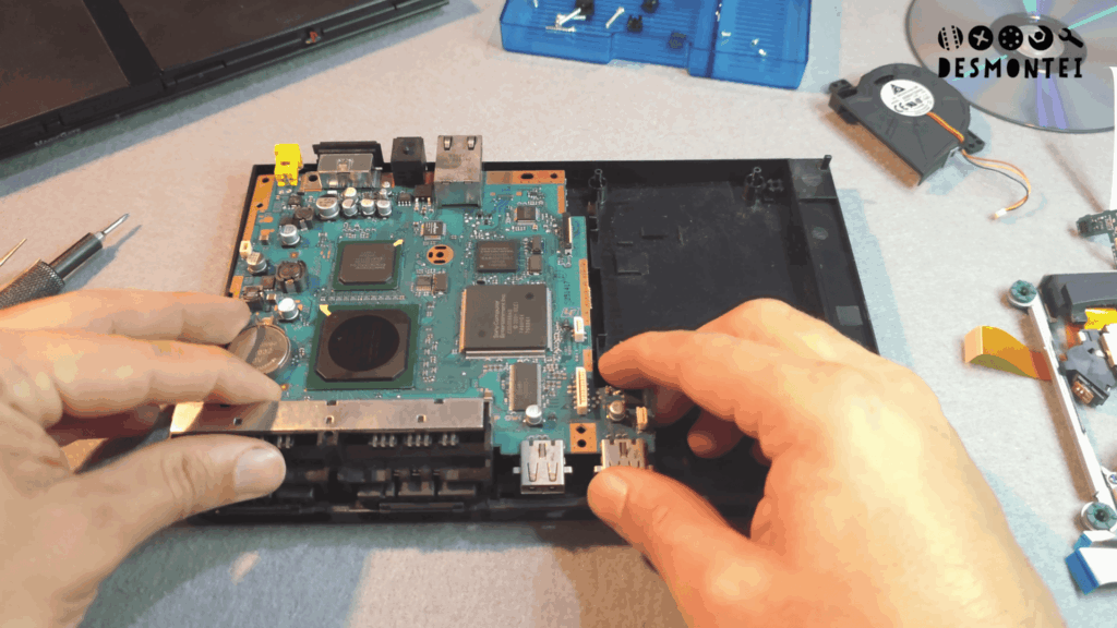 Teardown PS2 Slim mostrando mother board abaixo
