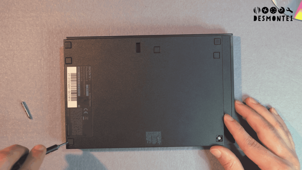 Teardown PS2 Slim mostrando a borracha do parafuso